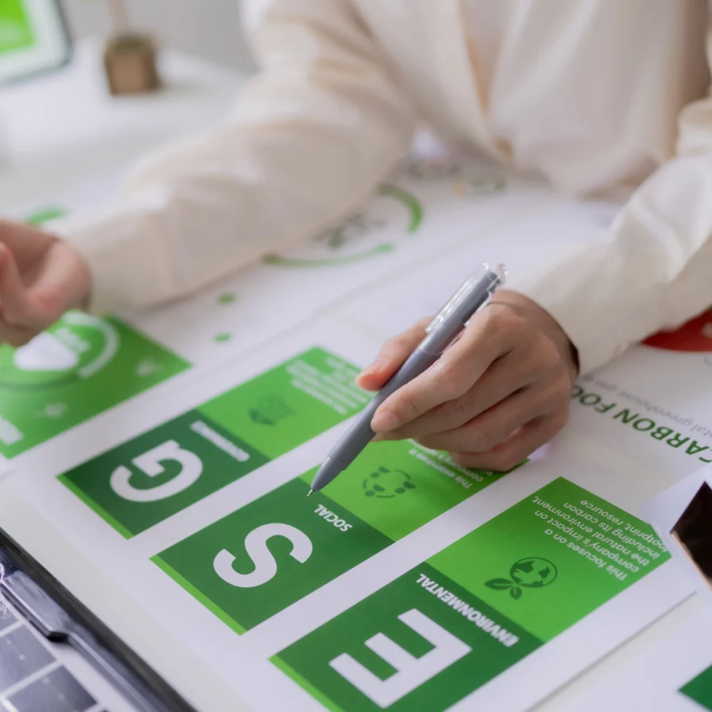 Mano con penna su un documento con le lettere E, S e G: ambiente, società e governance