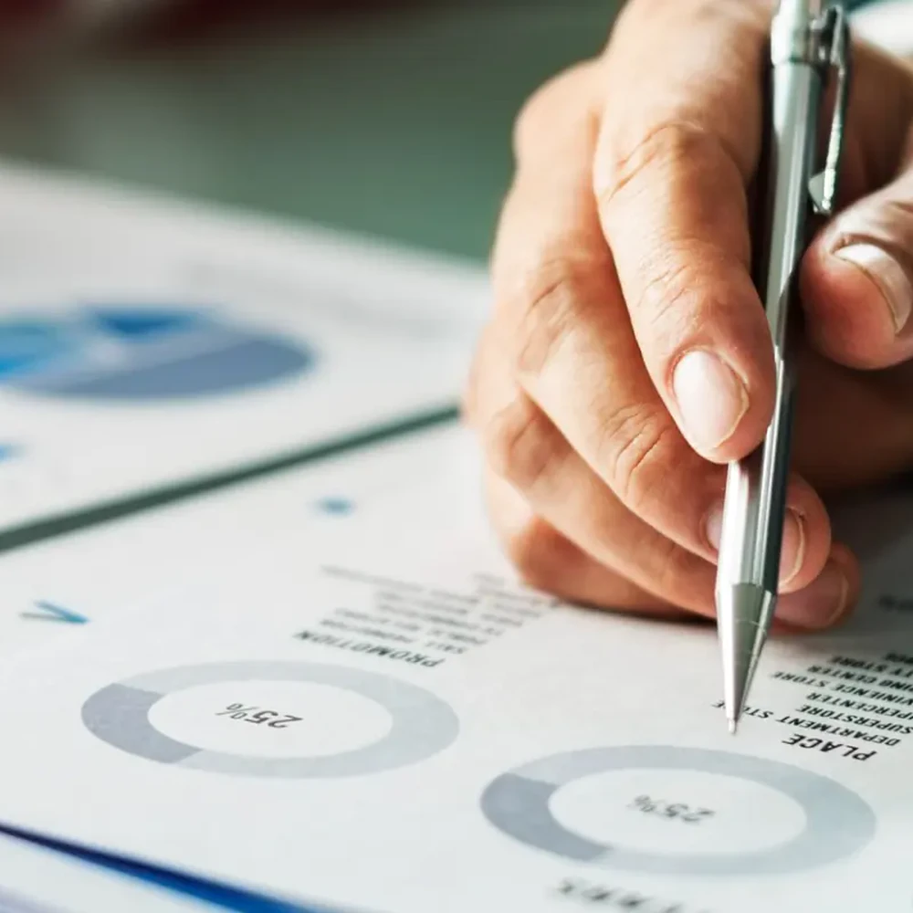 Mani che analizzano grafici e documenti con una penna